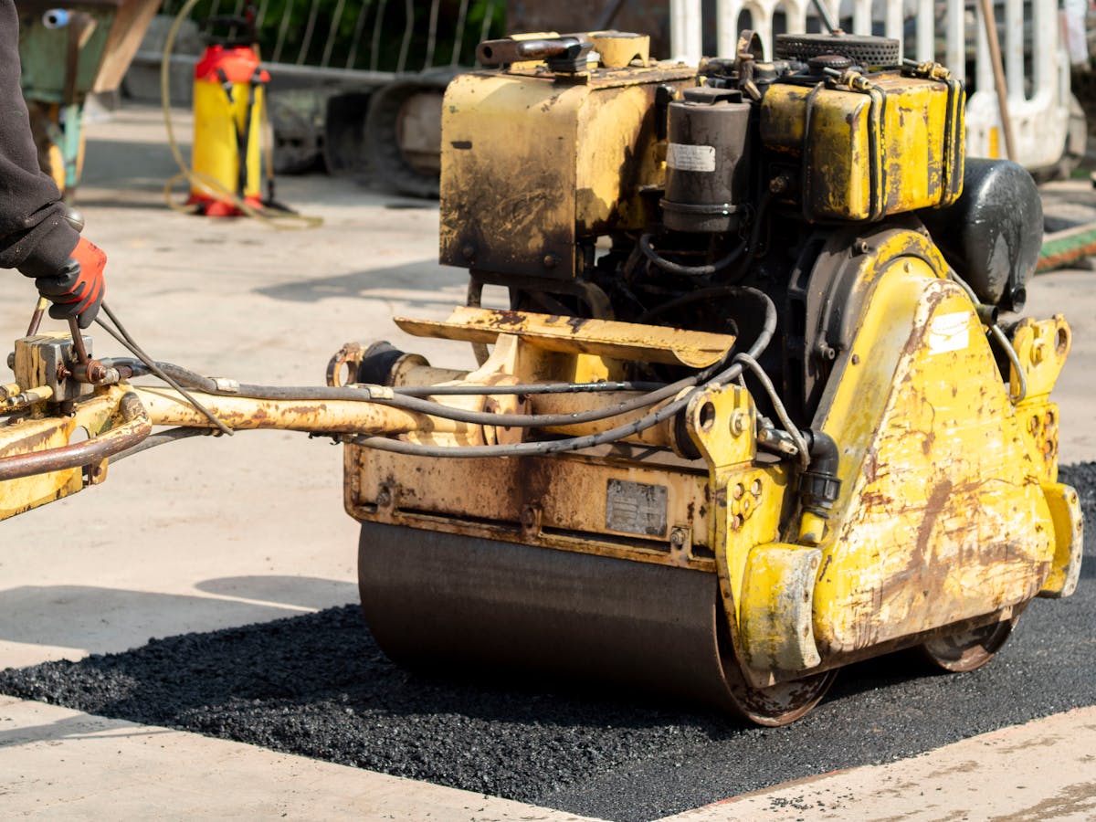 Asphalt pothole repair with a road roller compacting the patch