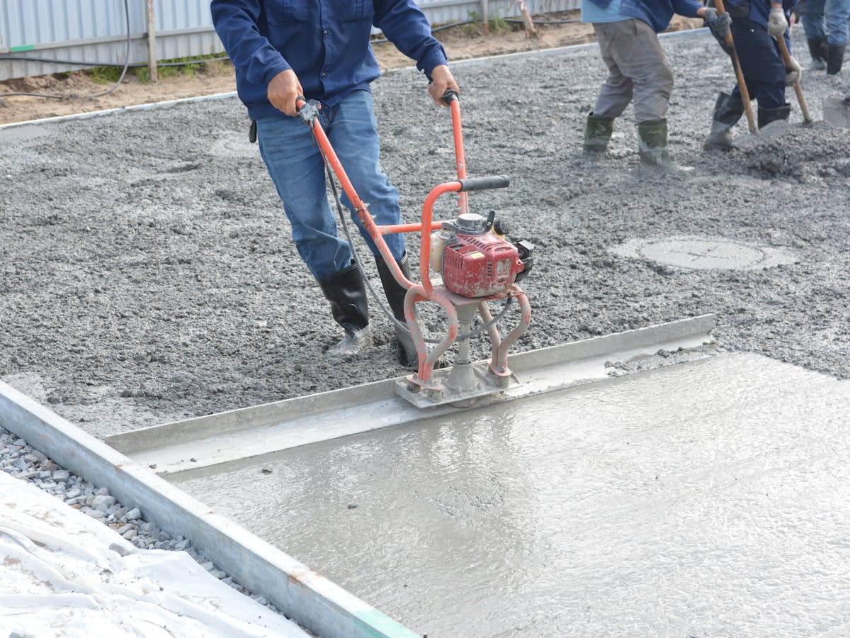 Construction workers finishing a fresh poured concrete surface