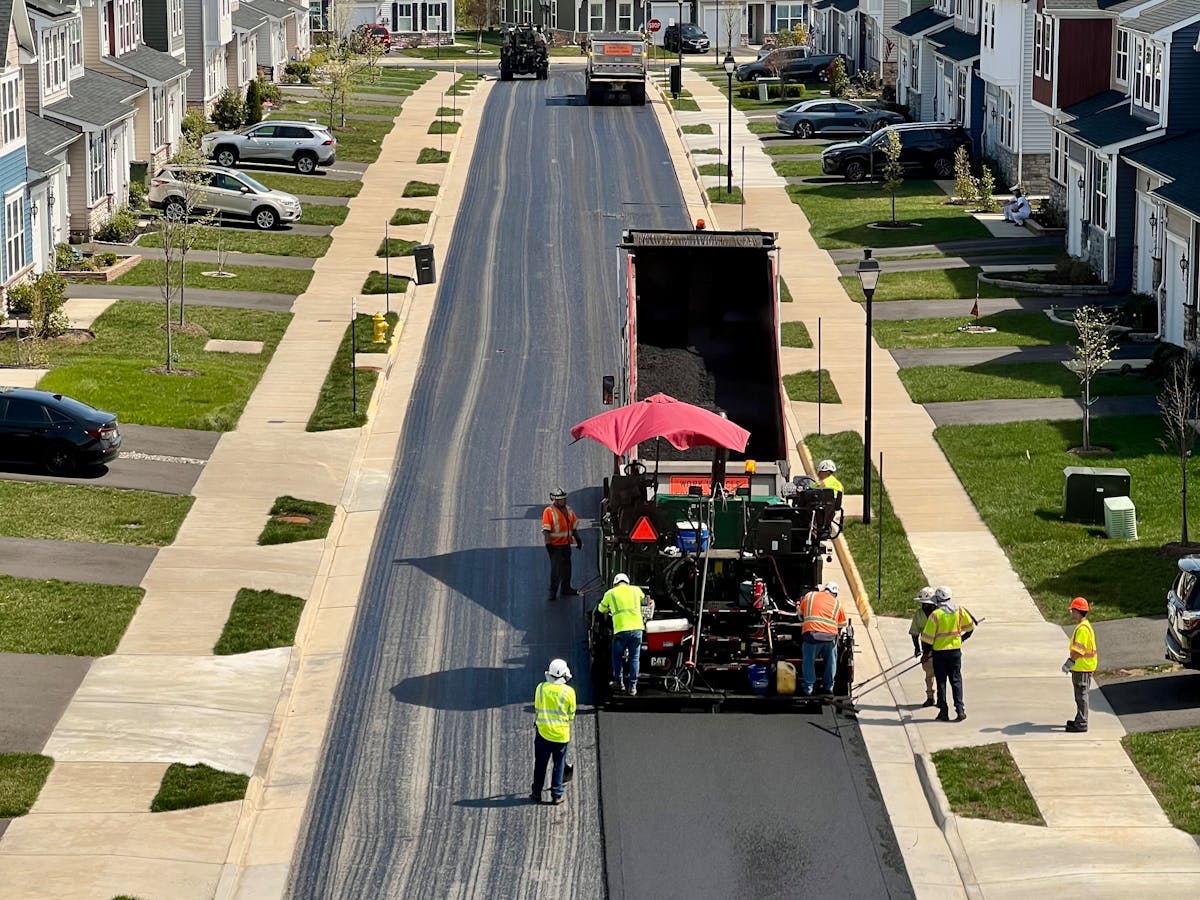Fresh asphalt paving along a newly surfaced street
